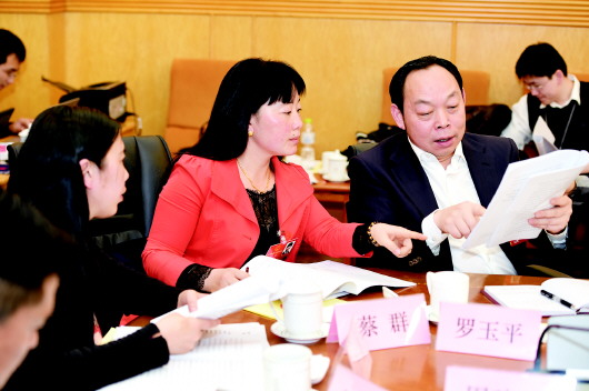 蔡群代表(中)和罗玉平代表(右)在分组审议全国人大常委会工作报告时交流。