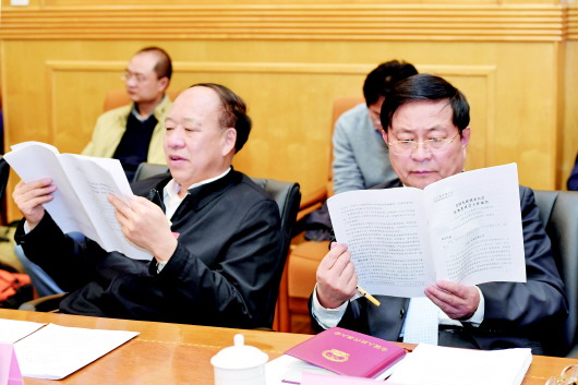 3月9日,贵州代表团举行代表小组会议,审议全国人大常委会工作报告。刘远坤代表(左)和周建琨代表在会上认真阅读文件。　记者　邓刚　摄