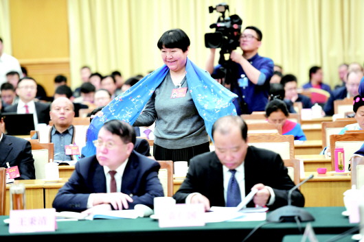 贵州代表团全体会议上,姚晓英代表展示贵州少数民族同胞手工制作的围巾。