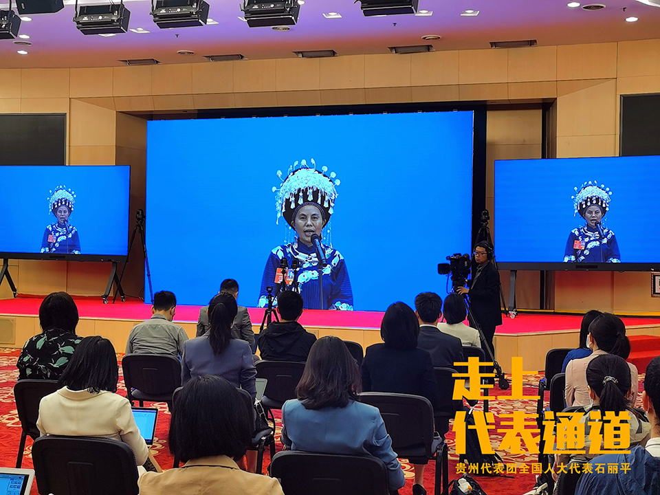 石丽平走上首场“代表通道”，在中外记者的镜头前，讲述传承苗绣，带领4000名妇女创业致富的故事